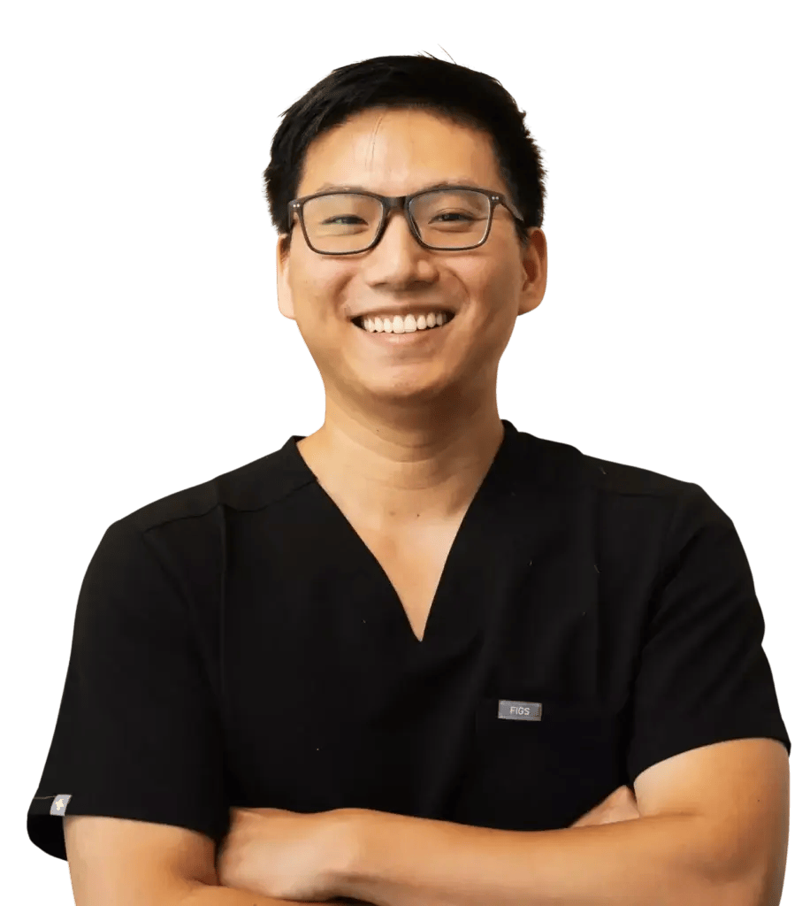 Comfort-focused dentist at Aster Smiles posing with arms crossed.